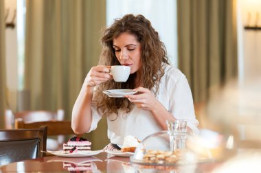 Portre genç gülümseyen kadın meyveli kek ve kahve kahve keyfi güzel / pasta dükkanı