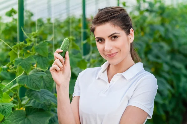 Feliz joven mujer sosteniendo pepinos — Foto de Stock