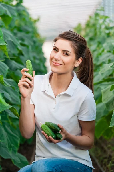 Happy Young woman holding cucumbers — Stock Photo, Image