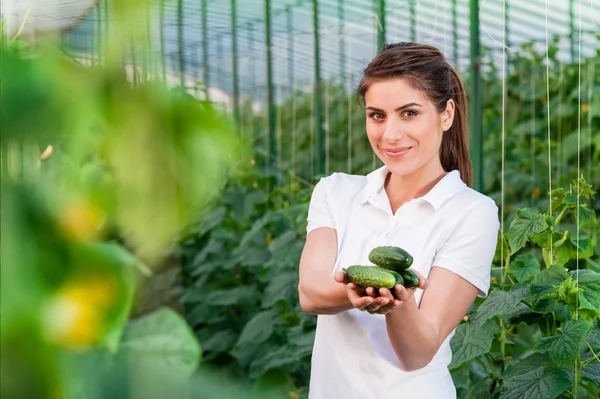 Happy Young woman holding cucumbers — ストック写真