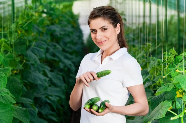 Happy Young woman holding cucumbers — Stockfoto