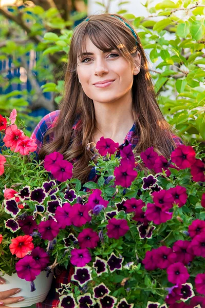Jonge vrouw planten bloemen in de tuin. — Stockfoto