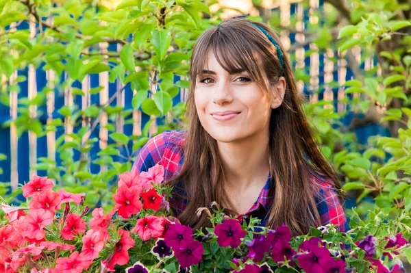 Jovem mulher plantando flores no jardim. — Fotografia de Stock