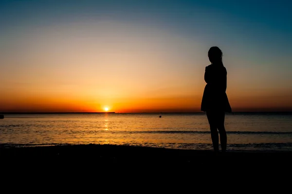 Silhouette einer Frau, die den Sonnenaufgang beobachtet — Stockfoto