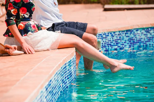 Verliebtes Paar spielt am Pool, elegant gekleidet. — Stockfoto