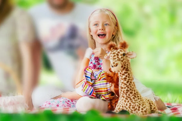 Schattige kleine meisje portret op de weide in zomerdag met haar favoriete speelgoed — Stockfoto