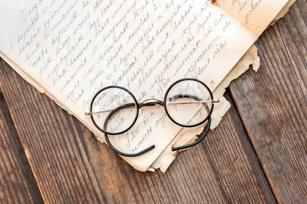 Libros antiguos y anteojos viejos sobre fondo de madera —  Fotos de Stock