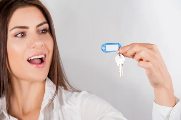 Mujer sonriente de negocios o agente de bienes raíces que muestra las llaves de la casa nueva, aislado sobre fondo blanco — Foto de Stock