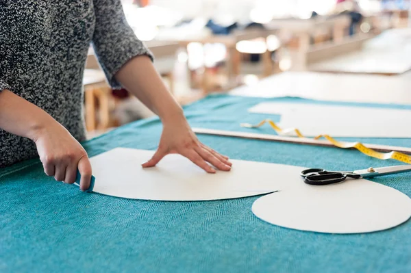 Женщина-модельер работает с эскизами в студии и выбирает ткань — стоковое фото