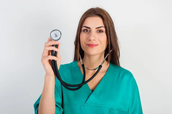 Woman in medical doctor uniform holding stethoscope — Zdjęcie stockowe