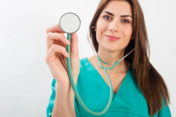 Woman in medical doctor uniform holding stethoscope — ストック写真