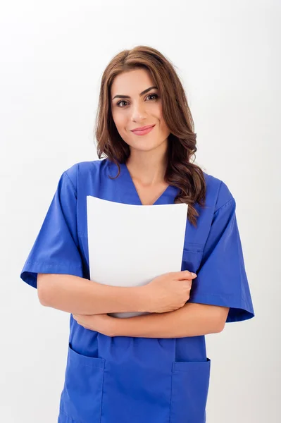 Una doctora / enfermera con uniforme médico sosteniendo una carpeta, aislada sobre fondo blanco —  Fotos de Stock