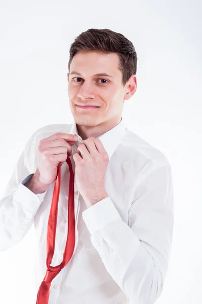 Young businessman tying a red tie — Stock Photo, Image