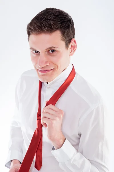 Young businessman tying a red tie — Stock Photo, Image