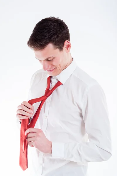 Young businessman tying a red tie — Stock Photo, Image