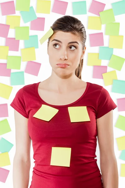 Busy woman against wall covered with colorful stickers — Stock Photo, Image