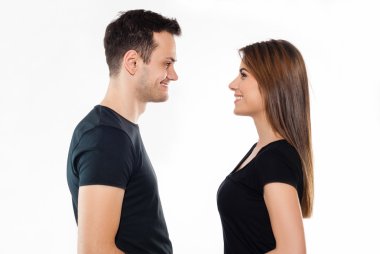 Çift ayakta beyaz arka plan üzerinde birbirlerine mutlu gülümseyen yüz yüze,.