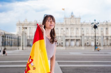 Palacio de kocaman bir gülümseme ile bir bayrak tutan Oriente - Madrid Kraliyet Sarayı önünde genç kadın.