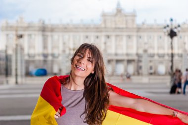 Palacio de kocaman bir gülümseme ile bir bayrak tutan Oriente - Madrid Kraliyet Sarayı önünde genç kadın.