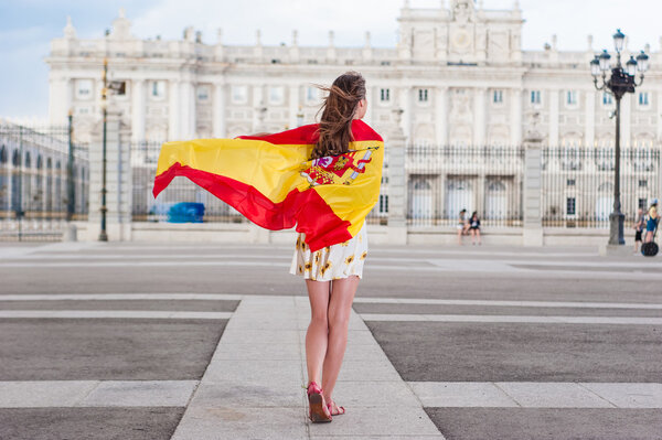 Mujer joven frente al Palacio de Oriente - Palacio Real de Madrid, con una bandera . — Foto de Stock