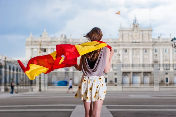 Jovem em frente ao Palácio de Oriente - Palácio Real de Madrid, segurando uma bandeira . — Fotografia de Stock