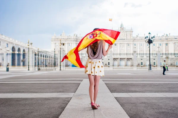 Jovem em frente ao Palácio de Oriente - Palácio Real de Madrid, segurando uma bandeira . — Fotografia de Stock