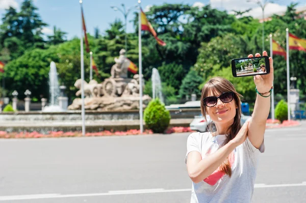 Jeune femme touristique prenant des photos avec la fontaine de Cibeles — Photo