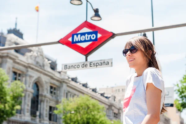 Young tourist woman in front of Madrid, Banco de Espana metro station. — Stockfoto
