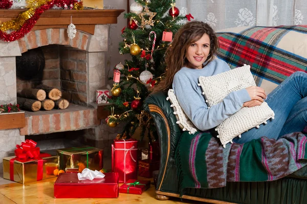 Happy young woman sitting on couch — Stock Photo, Image