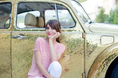 Altın Retro araba karşı oturan mutlu güzel kadın.