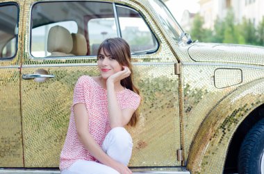 Altın Retro araba karşı oturan mutlu güzel kadın.