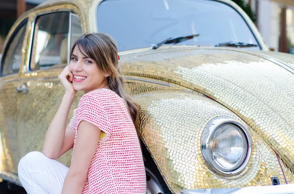 Happy Beautiful Woman Sitting Against Gold Retro Car. — Stock Photo, Image