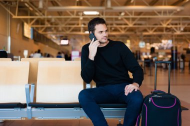 Onun cep telefonu ile rahat kıyafet içinde yakışıklı gülümseyen adam portresi