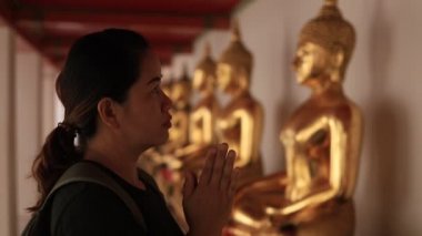 Buddha ile birlikte tapınakta dua eden Asyalı Kadın, Wat Pho Bangkok Tayland