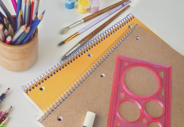 Cadernos e lápis, pintura, régua, borracha, pincéis em um branco — Fotografia de Stock
