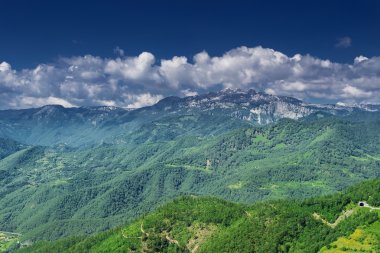 yeşil mavi bulutlu gökyüzü ile kaplı dağları