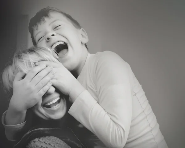 Oğlu anne kapanır gözleri gülen siyah ve beyaz eller — Stok fotoğraf