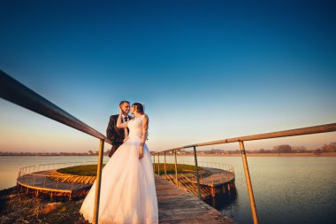 Güzel gelin kucaklama kürsüye yakın göl köprü