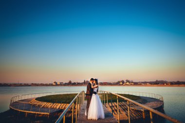 Güzel gelin kucaklama kürsüye yakın göl köprü