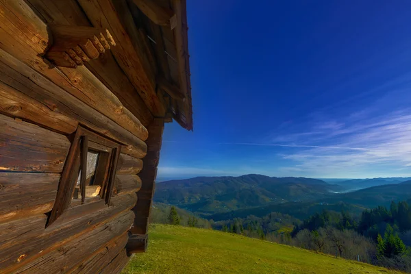 Cabaña de madera en las colinas de montaña — Foto de Stock