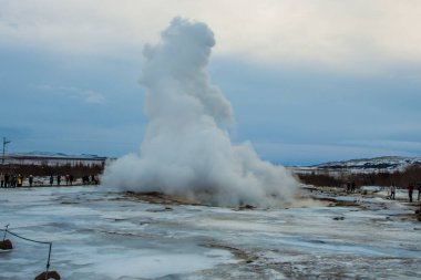 Konungshver gayzer buharı - Strokkur gayzerleri arka planda, İzlanda 'da patlar.