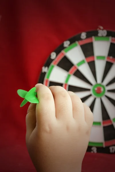 The hand holds a dart for darts.
