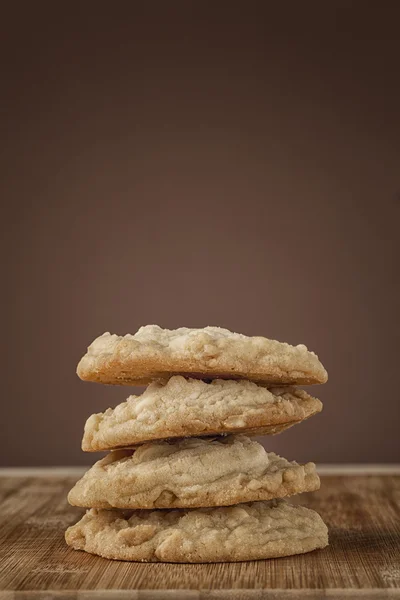 Stack of macadamia nut cookies on cutting board — Stock Photo, Image