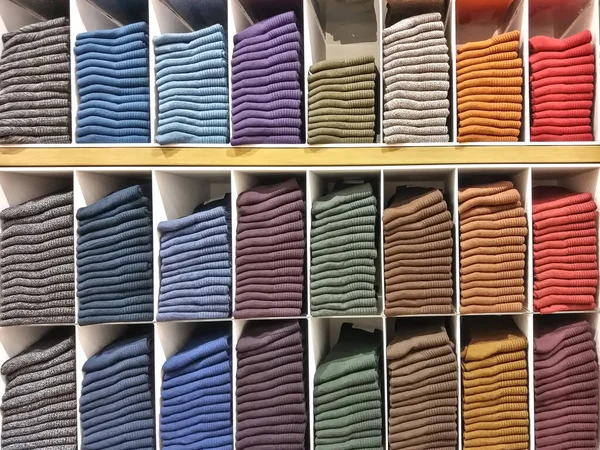 Kumaş satıcı tarafından katlanır. Müşterilerin satın almasını kolaylaştırmak için vitrine yerleştirilmiş..