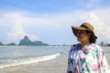 Kadın sahilde doğanın tadını çıkarırken rahatça gülümsedi..