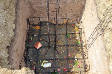 Temel güçlendirilmiş çelikten yapılmıştır ve çiçek yaprakları, yapraklar ve geleneksel ritüel nesnelerle serpilmiştir..