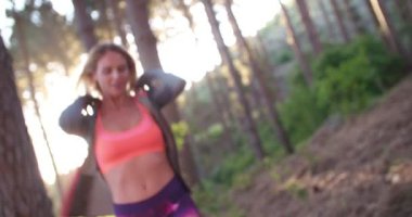 Bir ormanda gülümseyen kadın atlet 