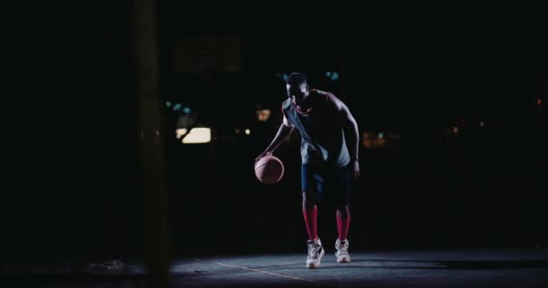 Baloncesto masculino jugador rebotando pelota en la cancha — Vídeo de stock