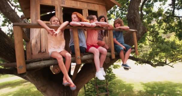 Niños en una casa del árbol sonriendo juntos como amigos — Vídeo de stock