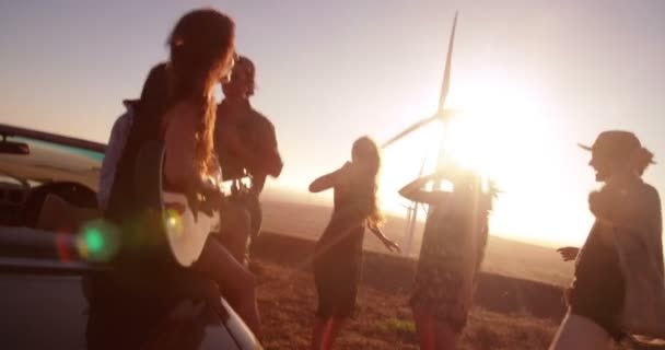 Flicka spela gitarr utomhus med vänner — Stockvideo